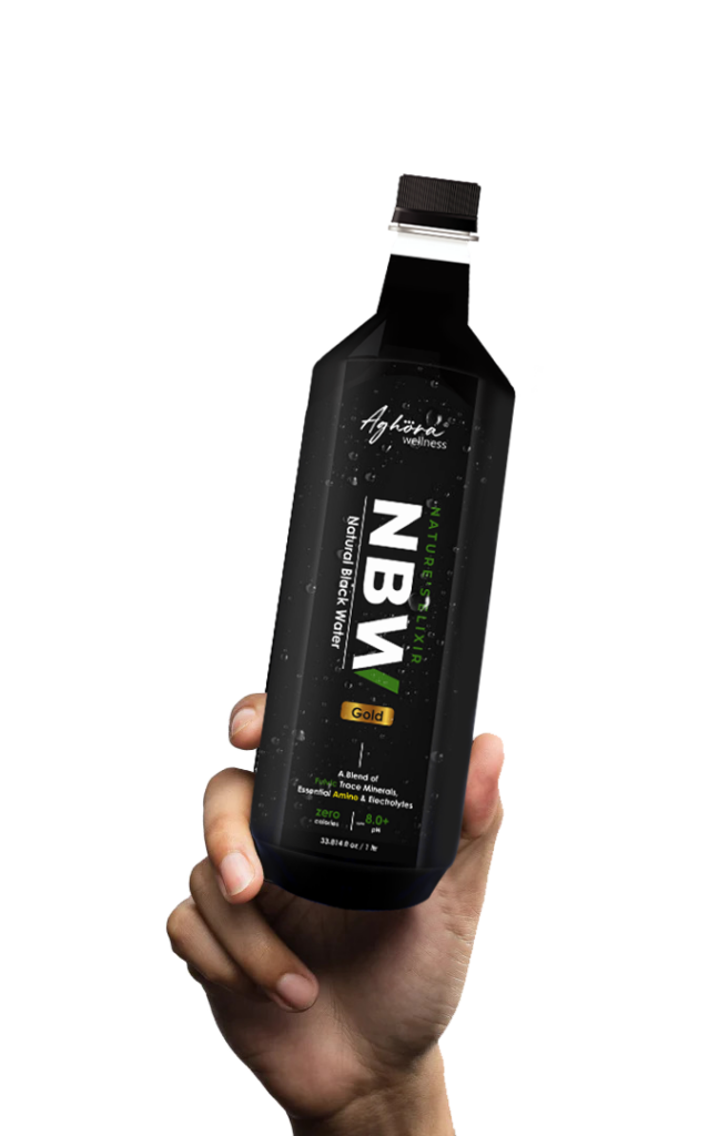 Hand holding a 500ml bottle of Aghora alkaline black water
